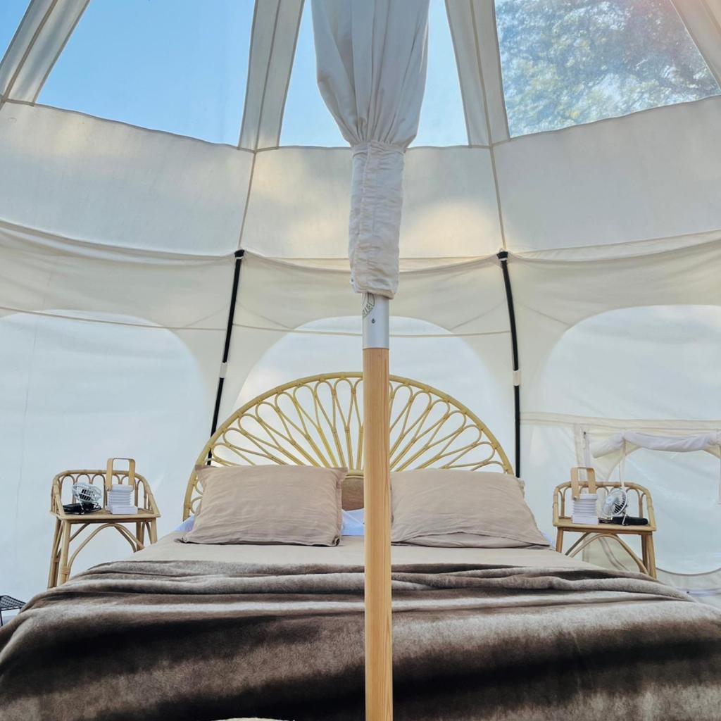 une chambre avec un lit dans une tente dans l'établissement La Prairie Étoilée Luxury Glamping - Adults Only, à Crozon-sur-Vauvre