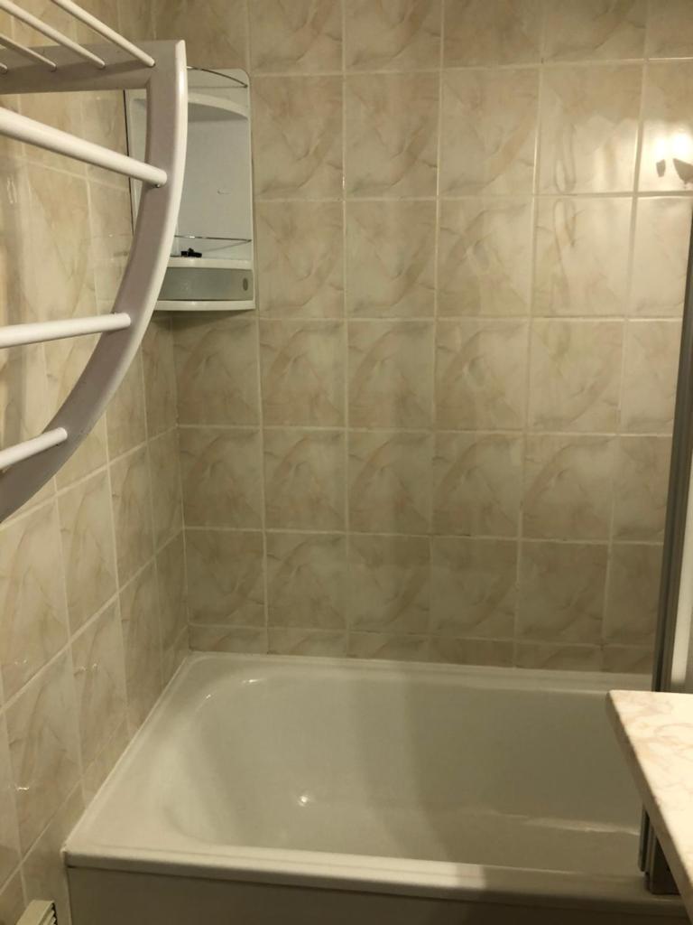 une salle de bain avec une baignoire et un lavabo dans l'établissement Charmant Studio, à Allos