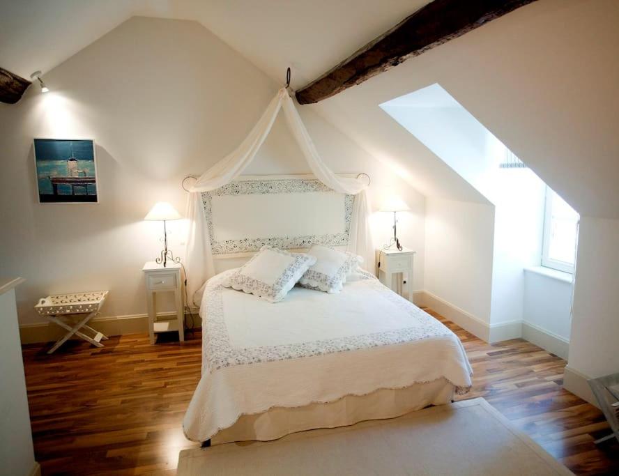 une chambre avec un lit blanc avec deux tables de nuit dans l'établissement Gîte de la corgette, à Saint-Romain