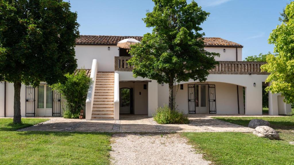 une vue extérieure d'une maison avec des arbres dans l'établissement LA CASA NEI VIGNETI 10, Emma Villas, à Catignano