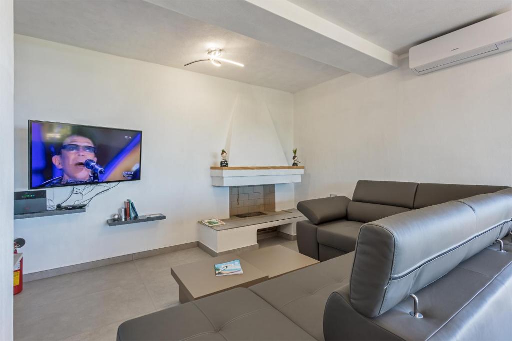un salon avec un canapé et une télévision à écran plat dans l'établissement Villa Perla Marina, à Tertenìa