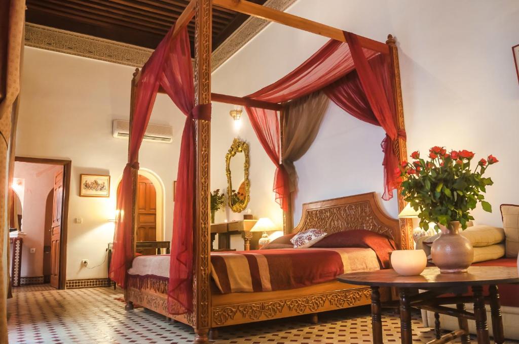 une chambre avec un lit à baldaquin et une table dans l'établissement Riad Zamane Fès - Boutique & Spa, à Fès