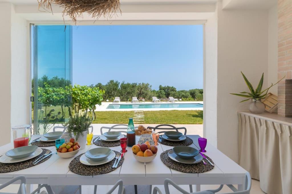 une table blanche avec des bols de fruits au-dessus dans l'établissement LaCorte di Ninetta., à Ostuni