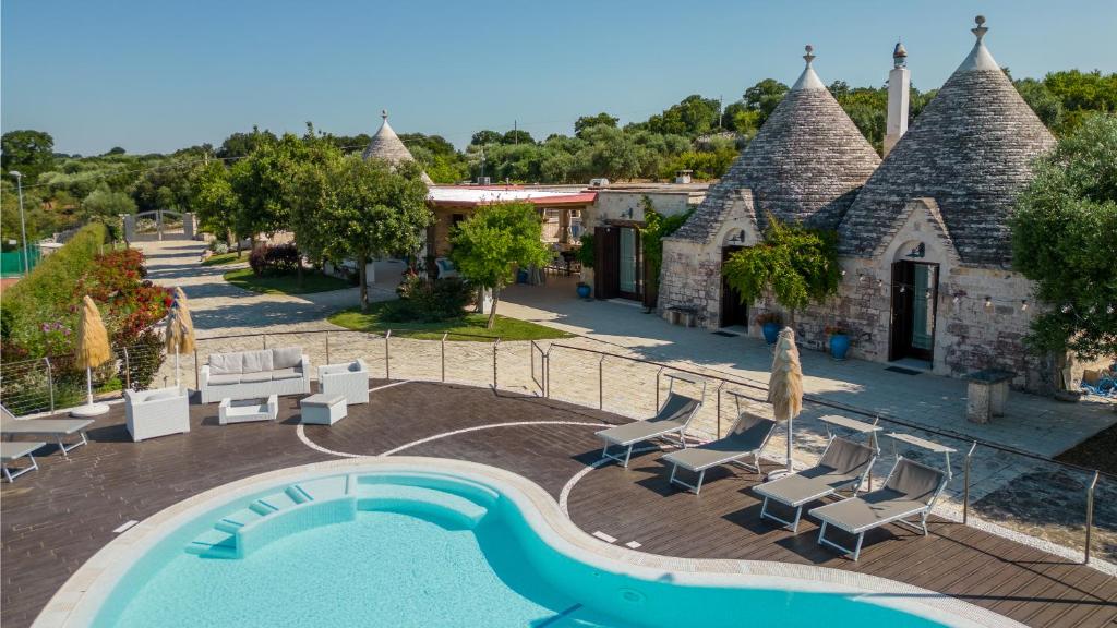 un complexe avec une piscine et un bâtiment dans l'établissement Trulli Ericla Luxury, à Castellana Grotte