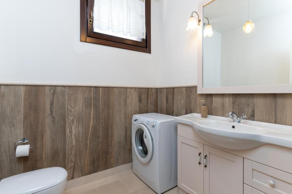 une salle de bain avec une machine à laver et un lavabo dans l'établissement Trulli Ericla Luxury, à Castellana Grotte 36 autres photos
