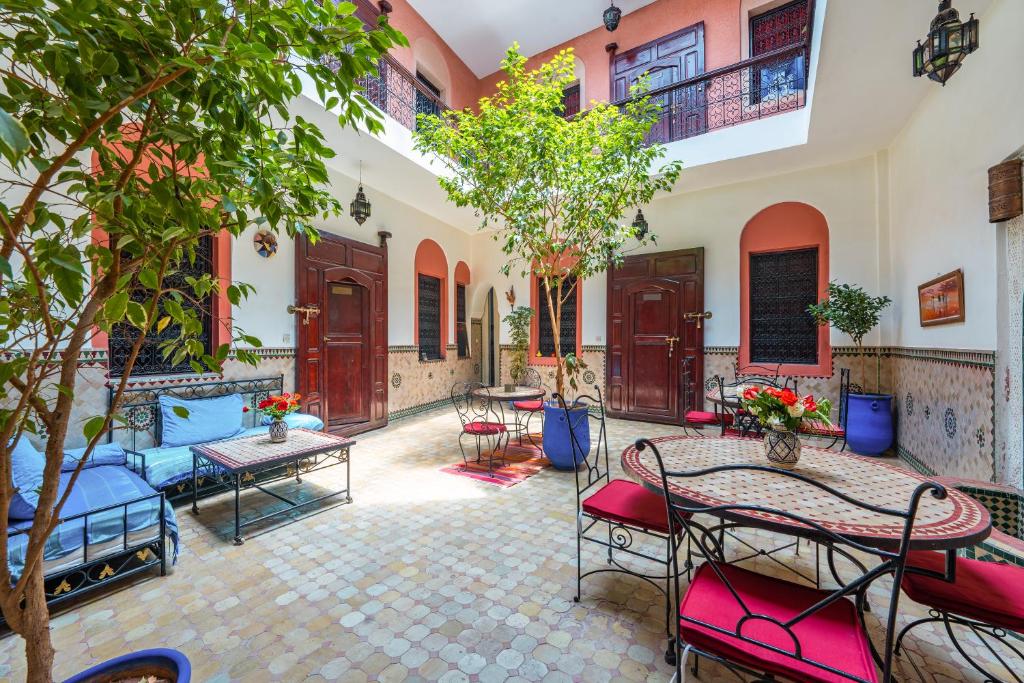 une cour avec des tables, des chaises et des arbres dans l'établissement Riad Todra, à Marrakech
