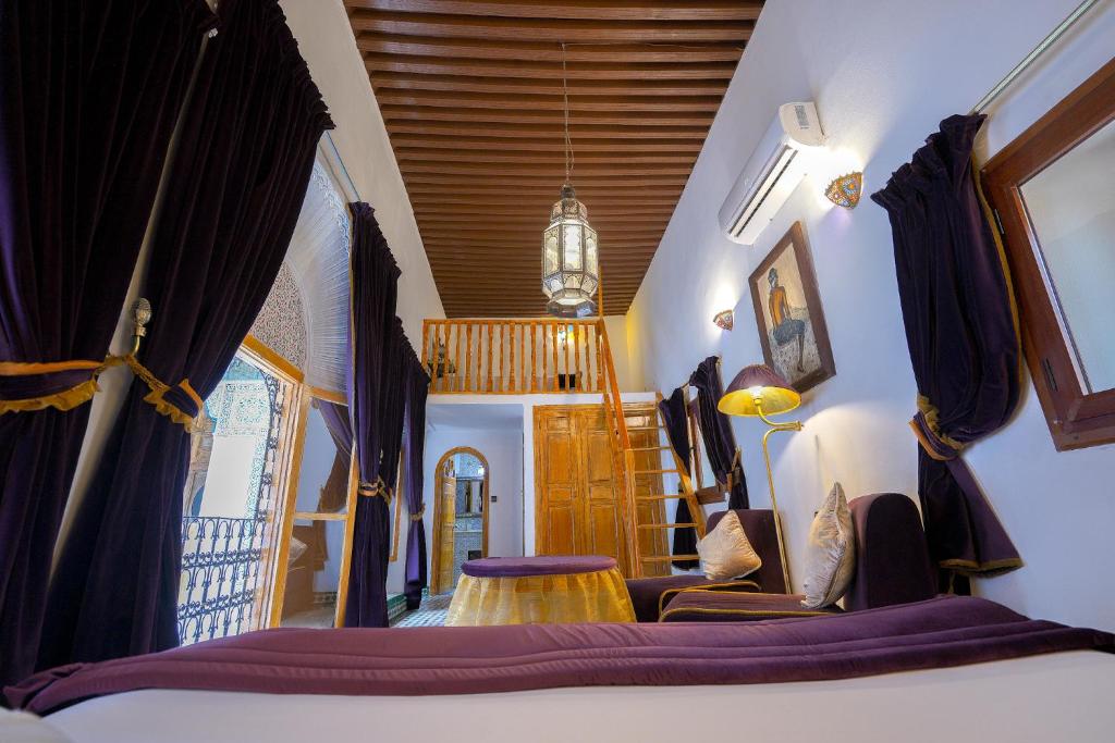 - une chambre avec un lit et des rideaux violets dans l'établissement Riad Sahraui, à Fès
