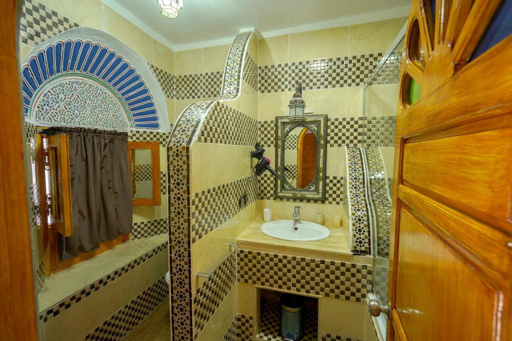 une salle de bain avec un lavabo et un miroir dans l'établissement Riad Sahraui, à Fès 37 autres photos