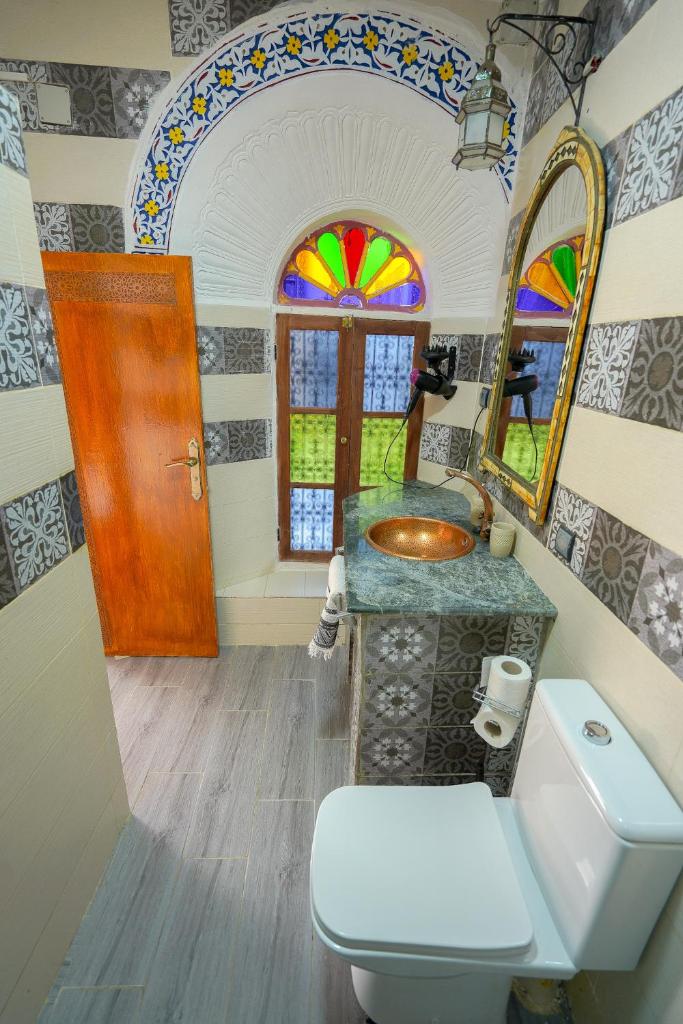 une salle de bain avec toilettes, lavabo et miroir dans l'établissement Riad Sahraui, à Fès
