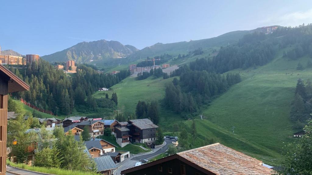 un petit village dans une vallée avec une montagne dans l'établissement Chez Angélique et Romain - Appartement agréable au pied des pistes, à La Plagne