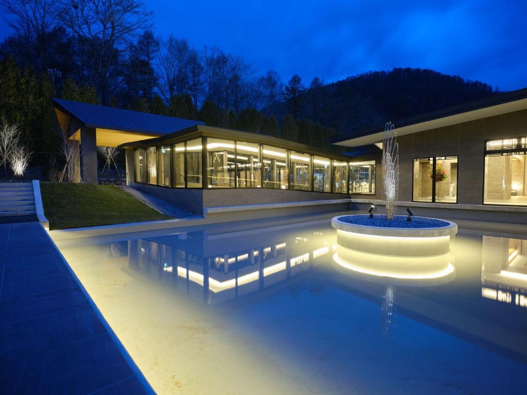un bâtiment avec une fontaine au milieu d'une piscine dans l'établissement Lake Toya Tsuruga Resort HIKARINOUTA, à Lac Tōya