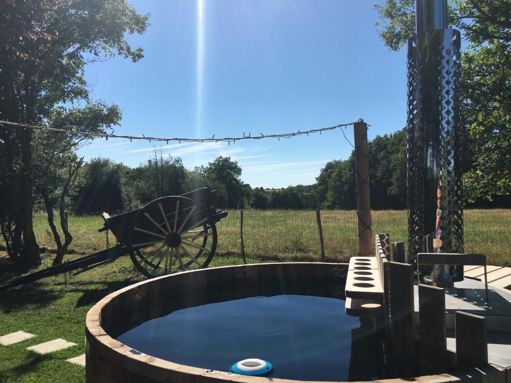 une petite piscine avec une brouette dans une cour dans l'établissement Le Nid du Tui, à Faverolles