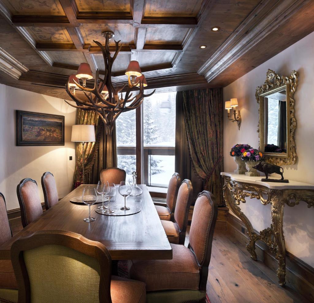 une salle à manger avec une table et des chaises et une fenêtre dans l'établissement Appartement d'Exception - Jardin Alpin - Courchevel 1850, à Courchevel
