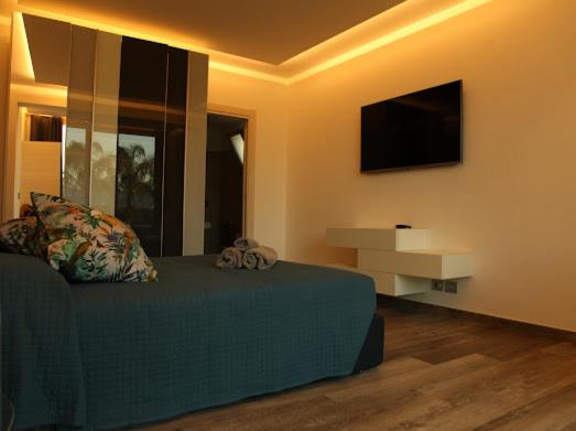 - une chambre avec un lit vert et une télévision à écran plat dans l'établissement T Villa, à Calatabiano