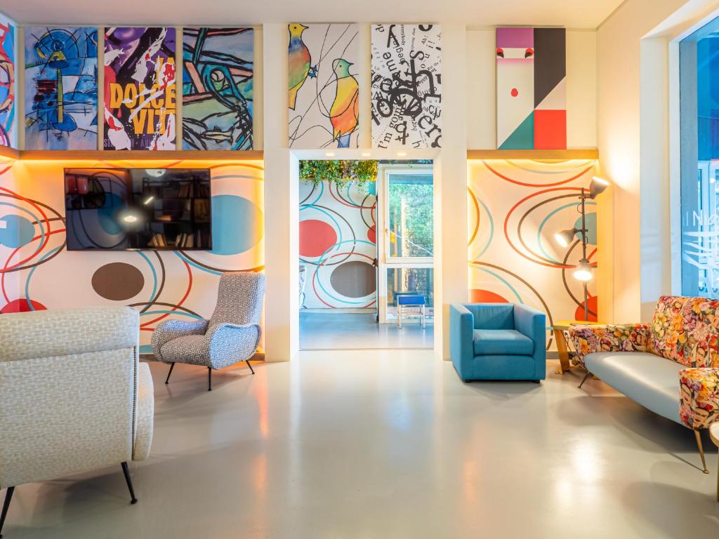 un salon avec des œuvres d'art colorées sur les murs dans l'établissement Hotel Il Nido, à Tellaro