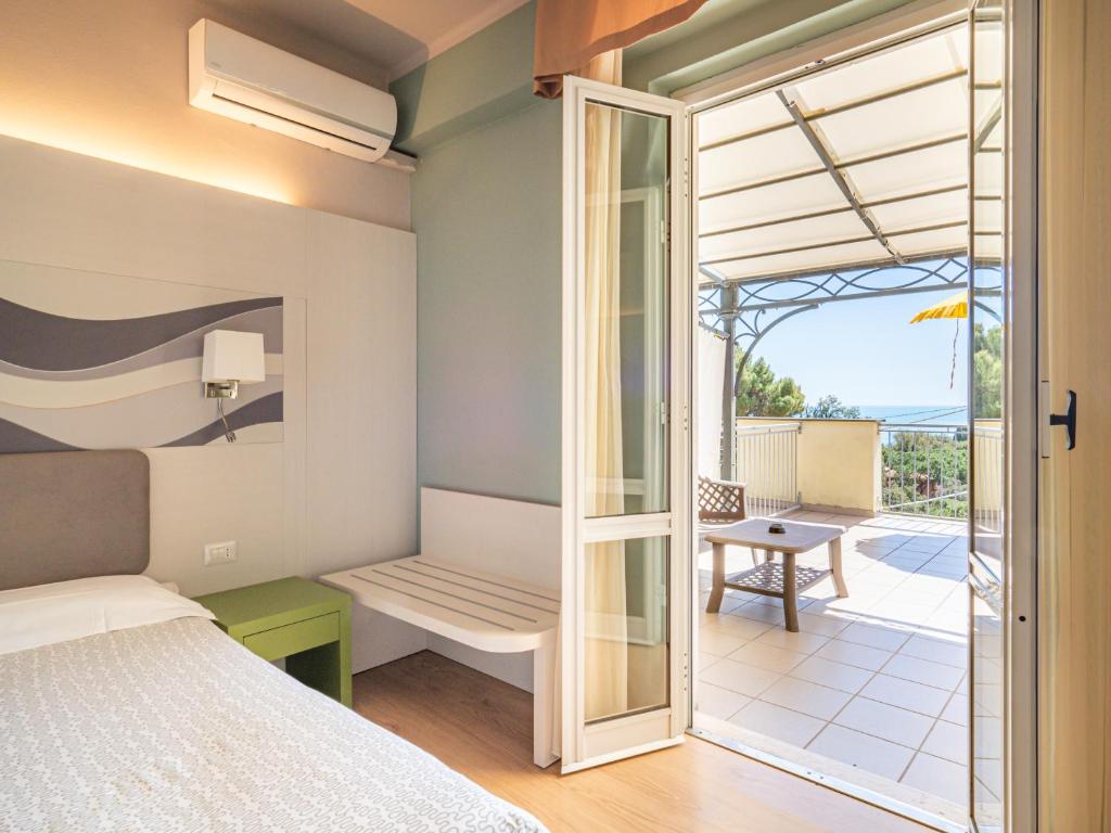 - une chambre avec un lit et une vue sur une terrasse dans l'établissement Hotel Il Nido, à Tellaro