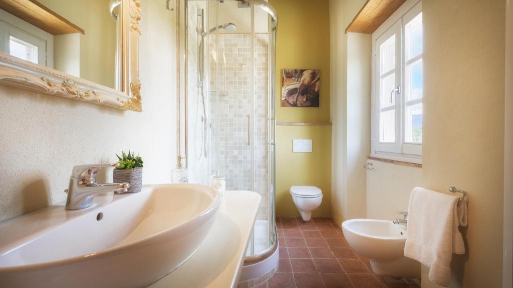 une salle de bain avec un lavabo et des toilettes et une fenêtre dans l'établissement VILLA IL MAGNIFICO 10, Emma Villas, à Reggello