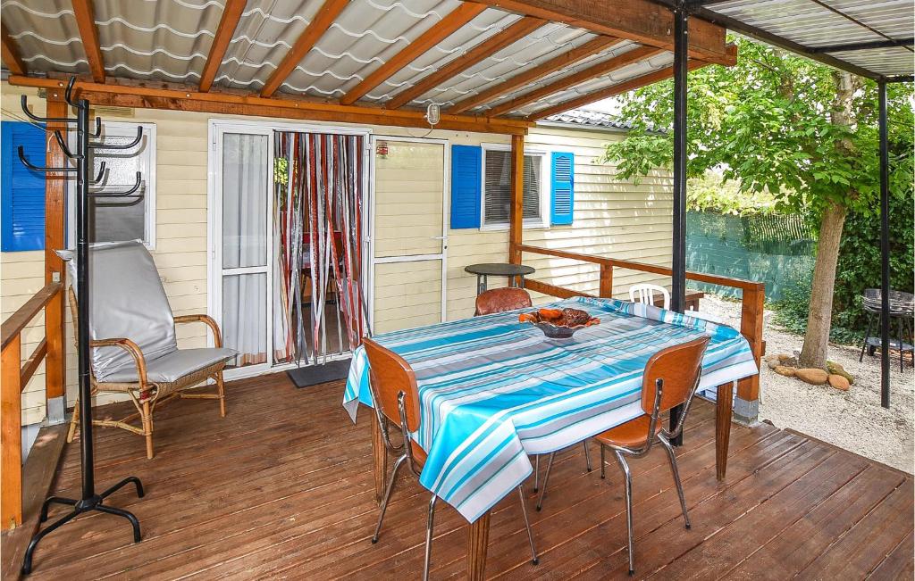 - une terrasse couverte avec une table et des chaises dans l'établissement Pet Friendly StaCaravan, à Entraigues-sur-la-Sorgue