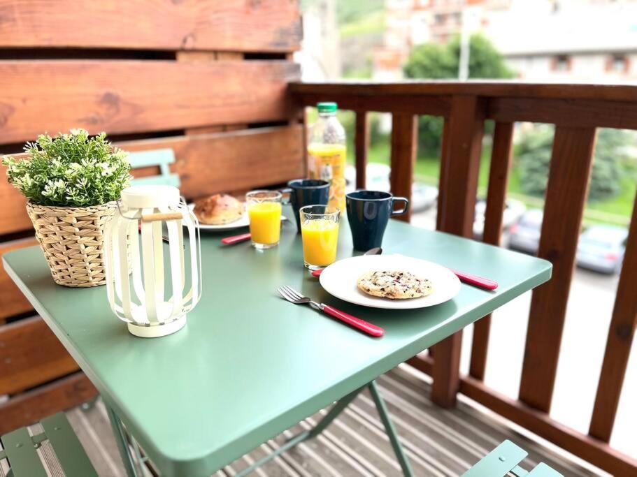 une table bleue avec de la nourriture et des boissons sur un balcon dans l'établissement Confort Moderne à Valberg - Terrasse avec Vue Panoramique 100 m des Pistes, à Valberg
