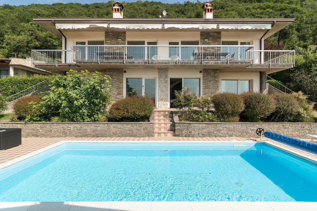 une maison avec une piscine devant une maison dans l'établissement Villa Montagne & Lago by Garda FeWo, à Villanuova sul clisi