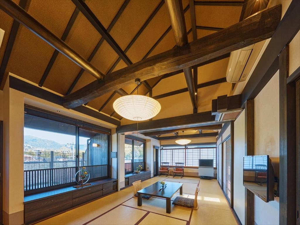 un salon avec une table et une grande fenêtre dans l'établissement Wakasa Annex, à Nara