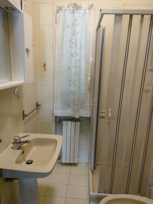 une salle de bain avec un lavabo, une douche et des toilettes dans l'établissement Alloggio turistico 7 min dall'Aeroporto, à Focene