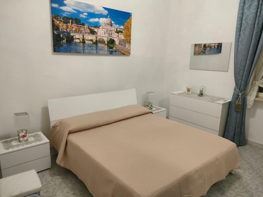 une chambre avec un lit et un tableau au mur dans l'établissement Alloggio turistico 7 min dall'Aeroporto, à Focene