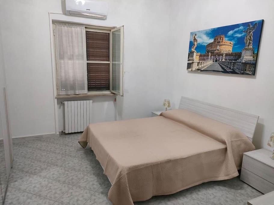 une chambre avec un grand lit et une fenêtre dans l'établissement Alloggio turistico 7 min dall'Aeroporto, à Focene