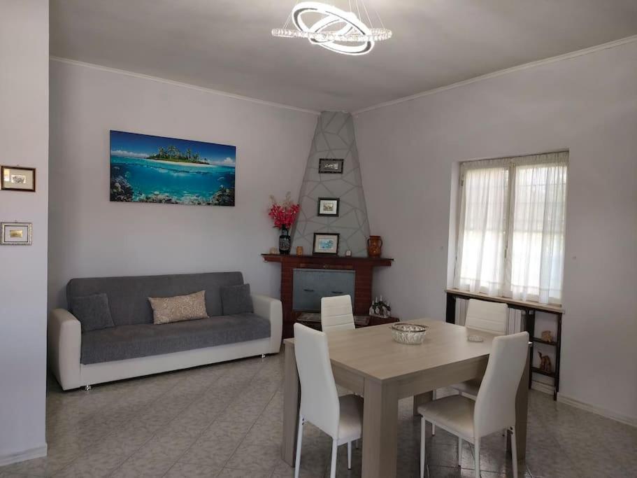 un salon avec une table et un canapé dans l'établissement Alloggio turistico 7 min dall'Aeroporto, à Focene