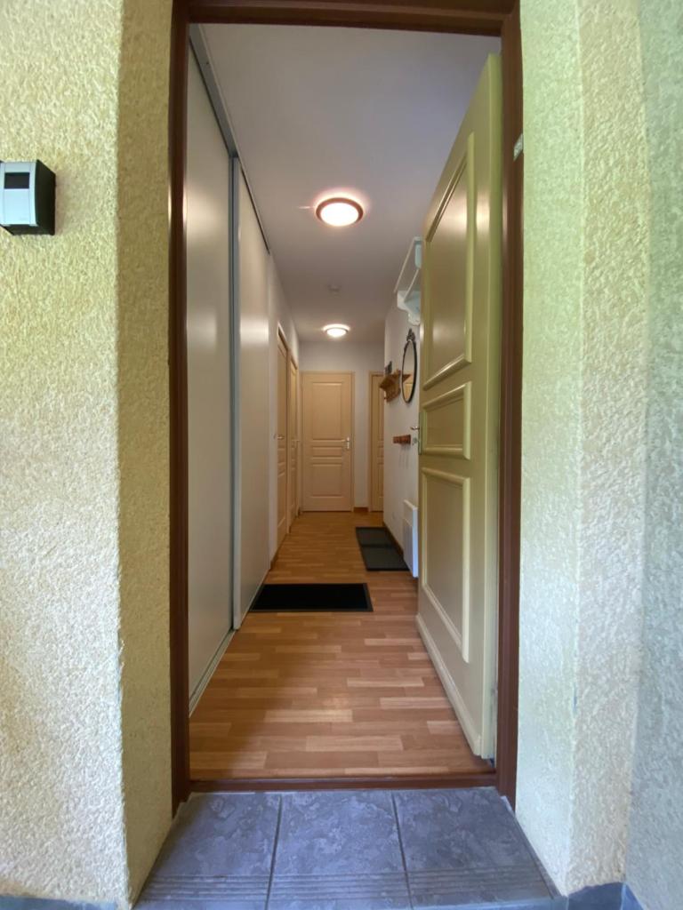 un couloir menant à une chambre avec porte dans l'établissement Les Granges d’Arvieux - Queyras - Appart 3ch./6p., à Arvieux