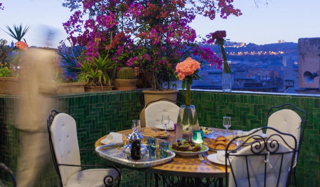 d'une table et de chaises sur un balcon fleuri dans l'établissement Riad La Maison Verte, à Fès