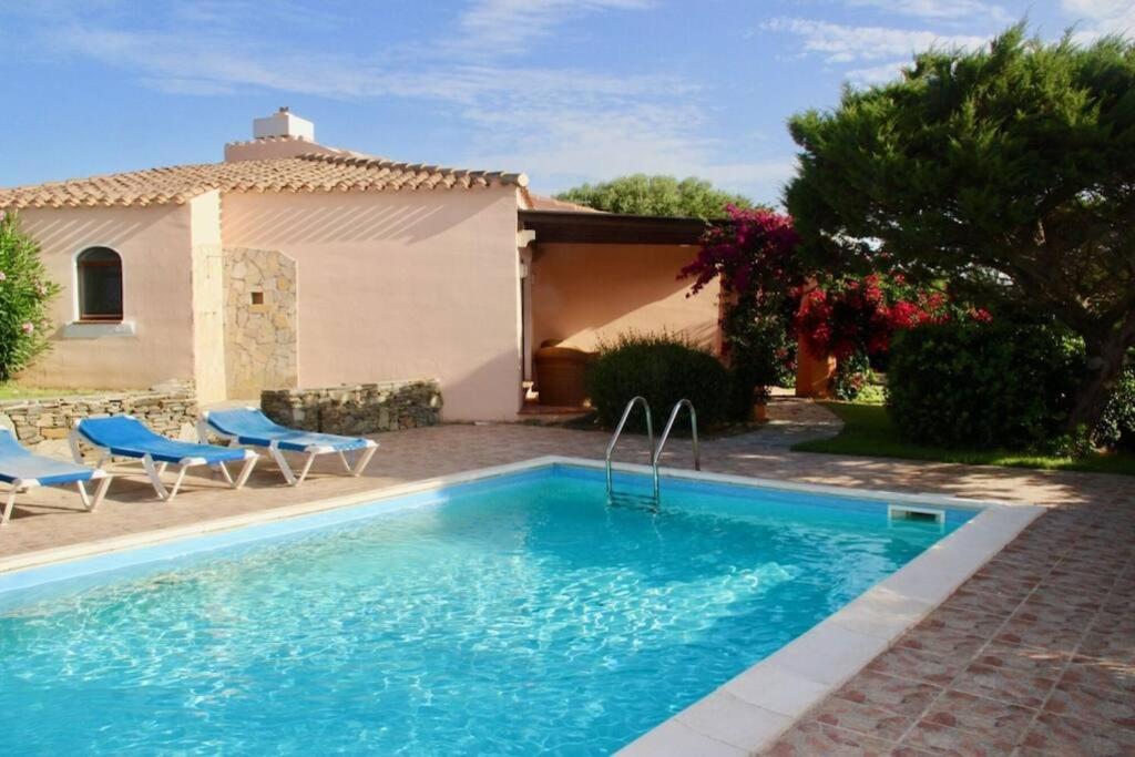 une piscine devant une maison dans l'établissement ClickSardegna Villa Regina Stintino sea view with pool and garden, à Cuile Pazzoni