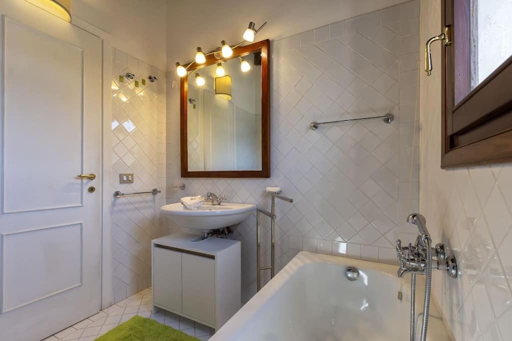 une salle de bain avec une baignoire, un lavabo et un miroir dans l'établissement ClickSardegna Villa Regina Stintino sea view with pool and garden, à Cuile Pazzoni 40 autres photos