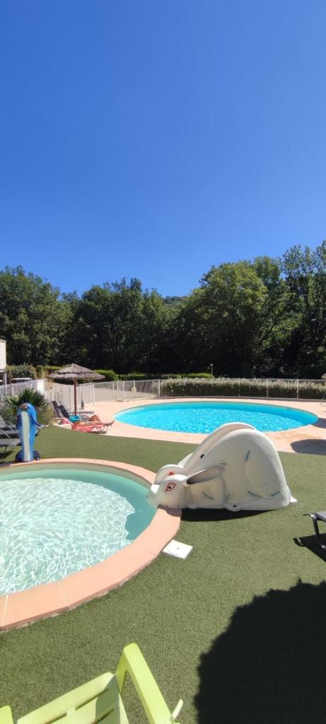 un jouet éléphant à côté d'une piscine dans l'établissement Camping Près du Lac de Sainte Croix, à Bauduen
