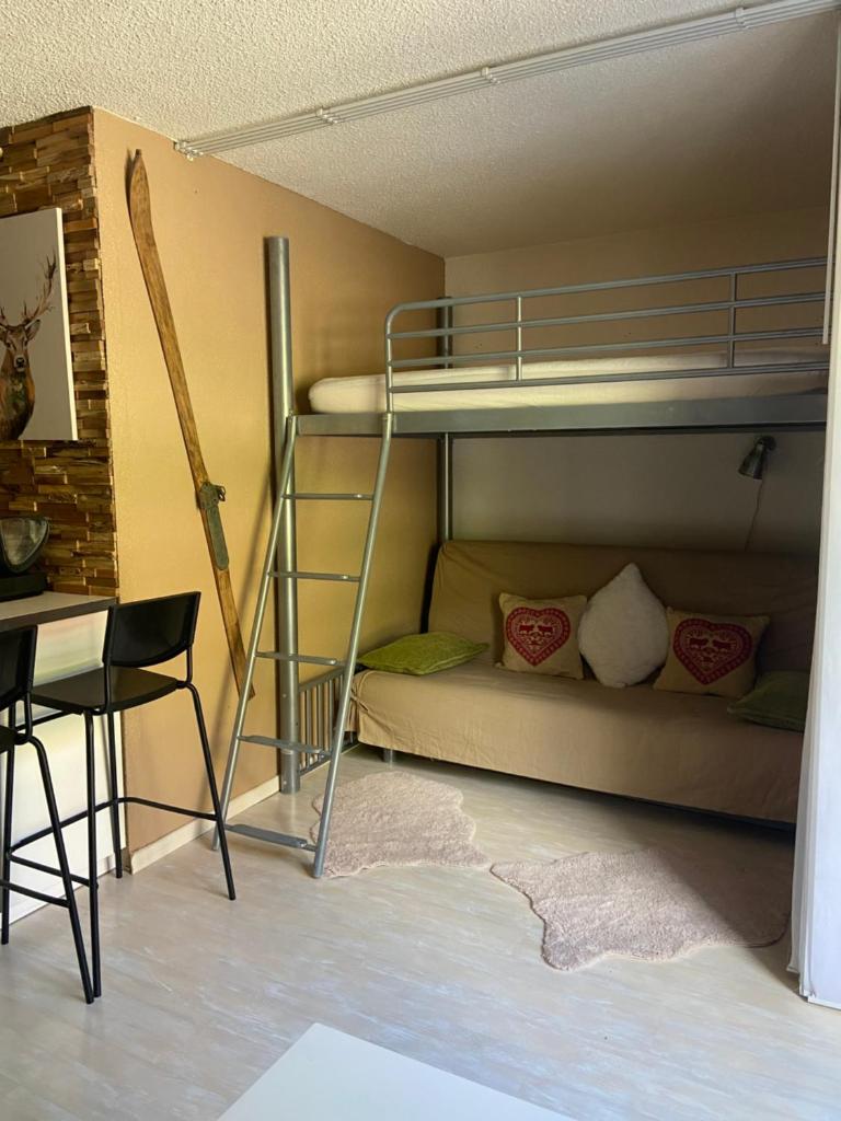 Cette chambre dispose de lits superposés, d'une table et d'un bureau. dans l'établissement Appartements au cœur de la station de ski "La Foux D'allos", à Allos
