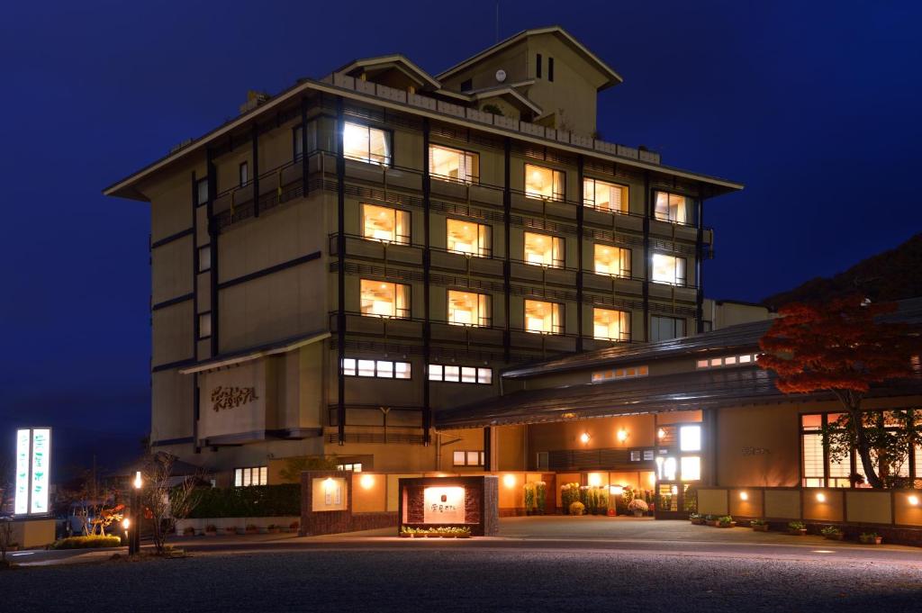 - un grand bâtiment avec des fenêtres éclairées la nuit dans l'établissement Sakaeya Hotel, à Tendō