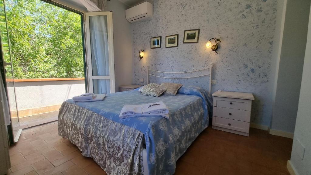 une chambre avec un lit avec une couverture bleue et une fenêtre dans l'établissement Villa Podere I Cavalieri, à SantʼAnna 34 autres photos