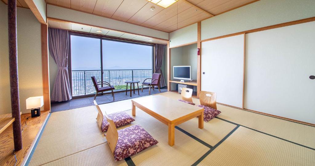 une pièce avec une table et des chaises et une grande fenêtre dans l'établissement Bizan Kaigetsu, à Tokushima