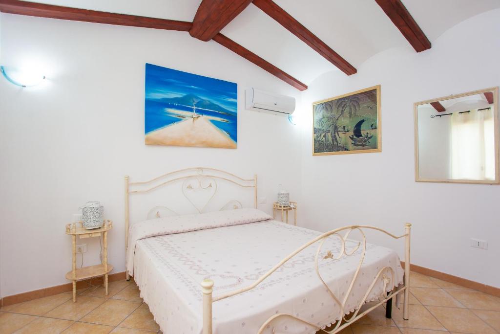 une chambre avec un lit blanc dans une pièce dans l'établissement Villa Funtana Cortese, à Orosei 24 autres photos