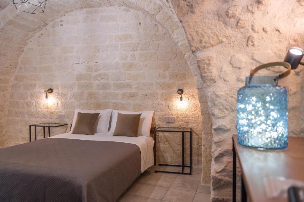 une chambre avec un lit dans un mur de pierre dans l'établissement Cà del Centro, à Manfredonia
