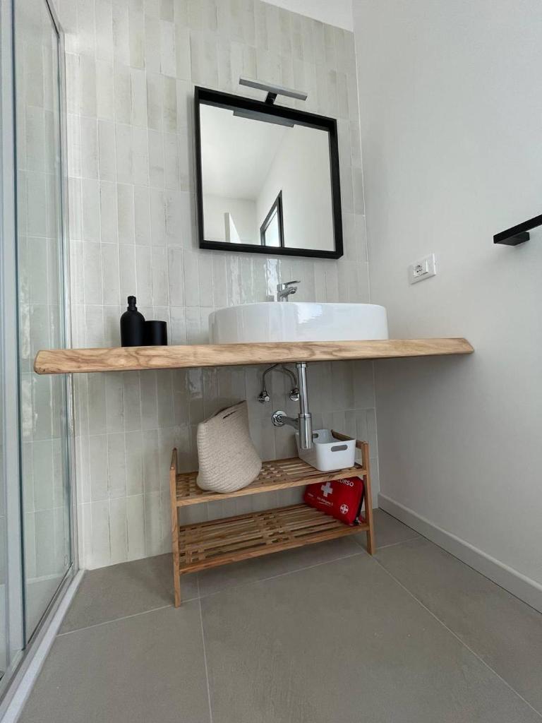 une salle de bain avec un lavabo et un miroir au mur dans l'établissement Dimore LE GRASTE - Made in Sicily, à Noto