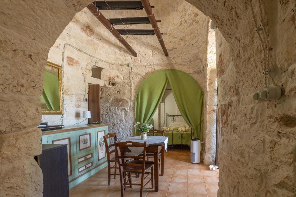 une cuisine et une salle à manger avec une table et des chaises dans l'établissement Trullo nonna Pina, à San Michele Salentino
