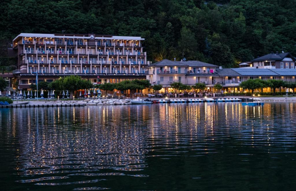 un grand hôtel au bord d'une étendue d'eau dans l'établissement Parc Hotel Du Lac, à Levico Terme
