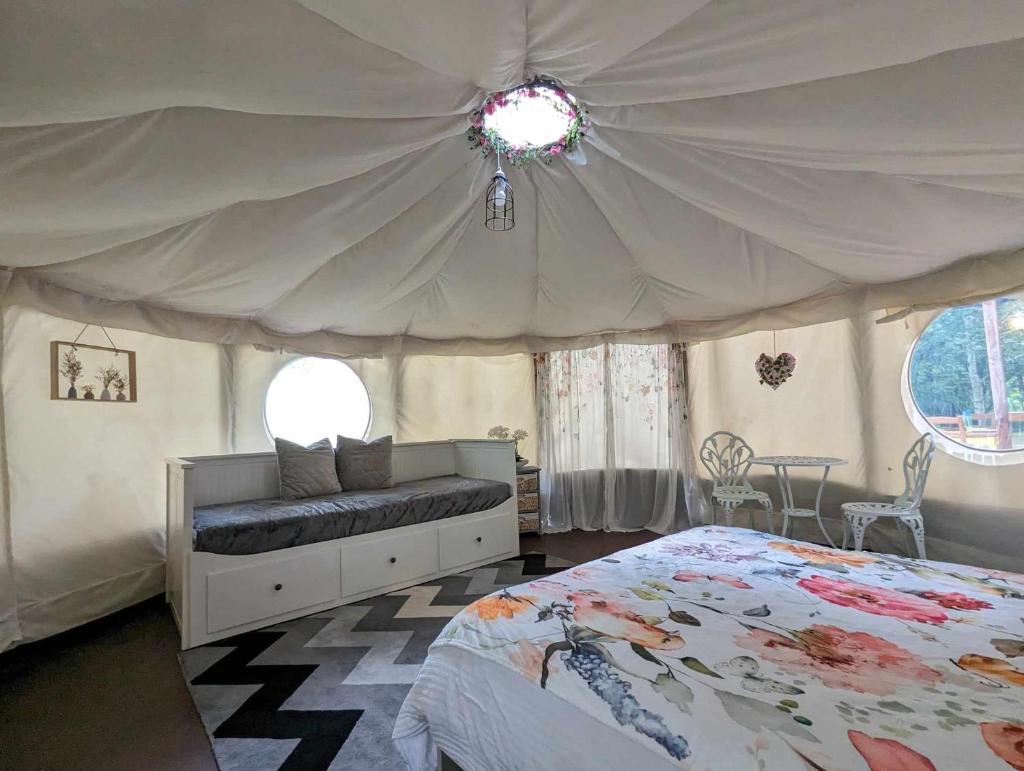 une chambre avec un lit à baldaquin dans l'établissement Luxury Glamping @Moulin des Forges, à Moutier-Malcard 29 autres photos