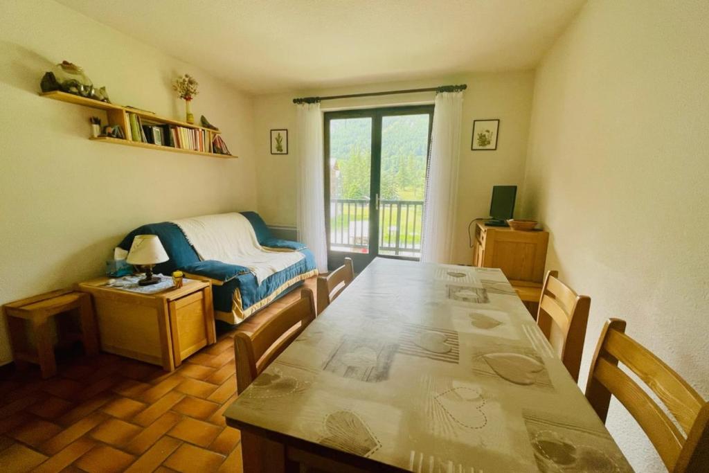 une salle à manger avec une table et un lit dans l'établissement 30 m next to Les Grands Bains, au Monêtier-les-Bains