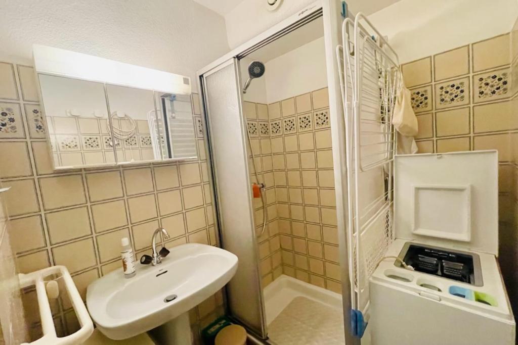 une petite salle de bain avec un lavabo et une douche dans l'établissement 30 m next to Les Grands Bains, au Monêtier-les-Bains