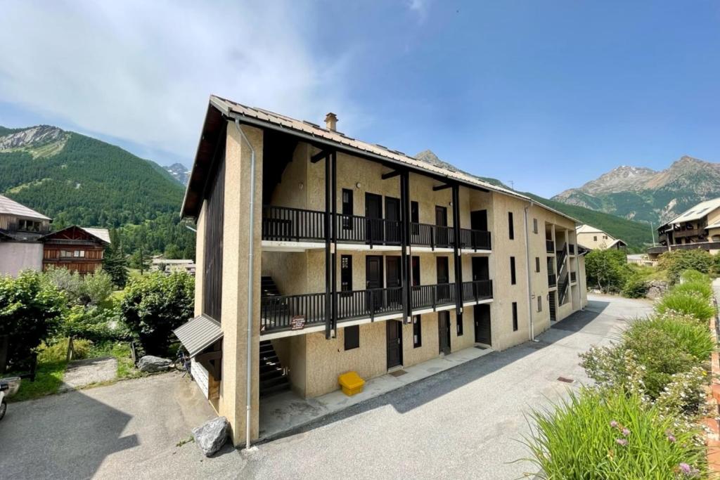 un bâtiment avec un balcon et des montagnes en arrière-plan dans l'établissement 30 m next to Les Grands Bains, au Monêtier-les-Bains 5 autres photos