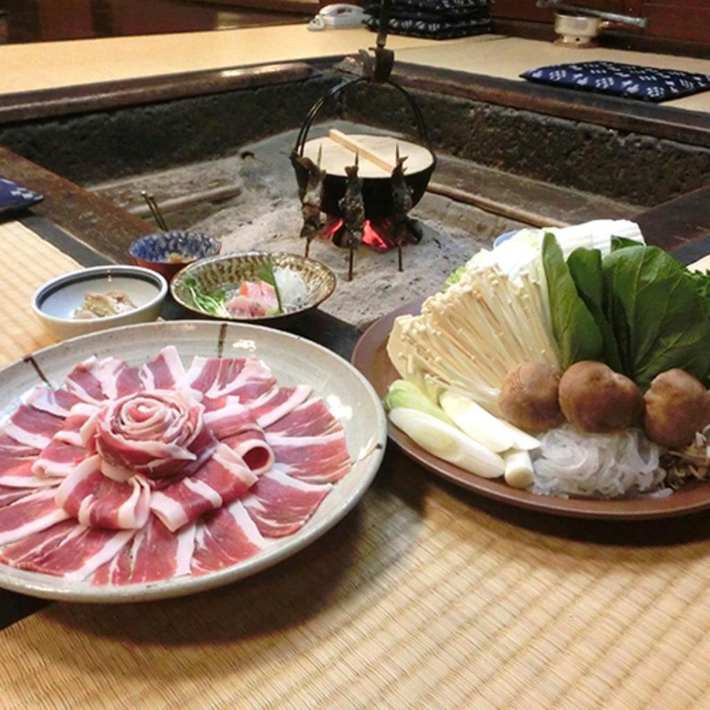 une table avec des assiettes de nourriture sur une table dans l'établissement 銭がめ, à Kanazawa