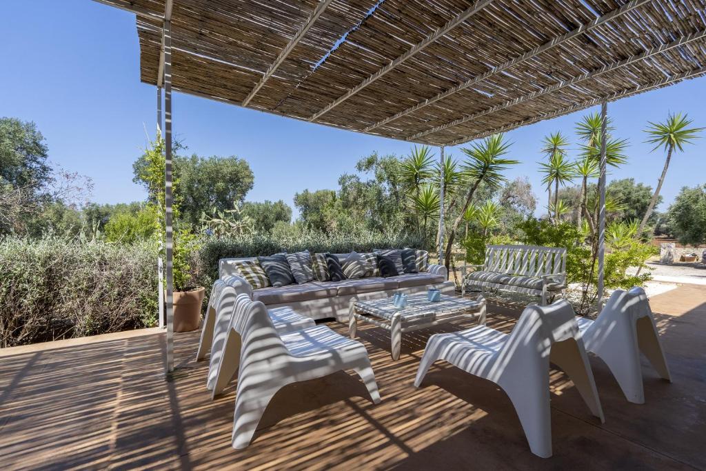 un patio avec un canapé et des chaises sur une terrasse dans l'établissement Villa Marta, à Carovigno
