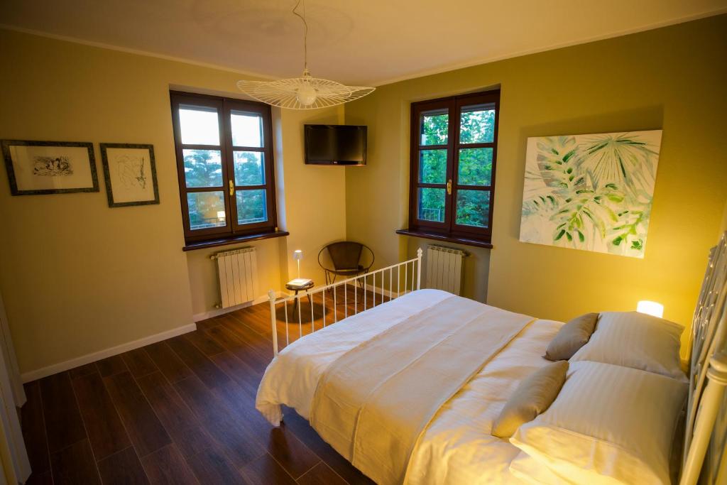 une chambre avec un lit et deux fenêtres dans l'établissement Villa Monforte Barolo with private pool - LANGHE GATEWAY, à Monforte dʼAlba
